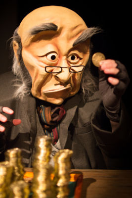 Ebenezer Scrooge gazes upon what he loves most in life: money. ‘A WONDERHEADS Christmas Carol’ is a whimsical reimagining of the holiday classic, touring BC theatres this December. Kate Braidwood as Scrooge. Photo by Daryl Turner (Dimensions: 2533 x 3800px • File Type: JPG • File Size: 2MB) Ebeneezer Scrooge admires a gold coin. From 'A WONDERHEADS Christmas Carol' by WONDERHEADS, a physical theatre company specializing in full-face mask performance.