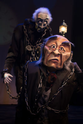 Marley’s Ghost looms behind Ebenezer Scrooge in ‘A WONDERHEADS Christmas Carol,’ a whimsical reimagining of the holiday classic touring BC theatres this December. Kate Braidwood as Scrooge, Jessica Hickman as Marley. Photo by Daryl Turner (Dimensions: 2500 x 3750px • File Type: JPG • File Size: 2MB) Marley's Ghost looms behind Ebenezer Scrooge. From 'A WONDERHEADS Christmas Carol' by WONDERHEADS, a physical theatre company specializing in full-face mask performance.